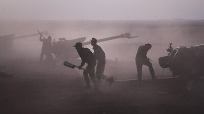 Syrian army personnel load howitzers last week. Alexander Kots / AP