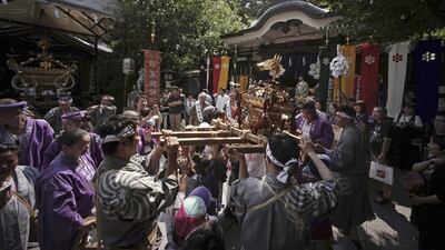 Residents and children from a local neighborhood carry a portable shrine to celebrate their festival at Torigoe Shrine in Tokyo. Eugene Hoshiko / AP Photo