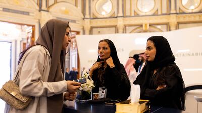 Female employees assist a guest at the conference. Bloomberg