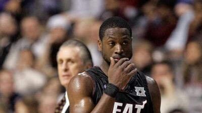 Miami Heat guard Dwyane Wade, right, walks back to the court while Heat president Pat Riley looks on. AP Photo/Carlos Osorio