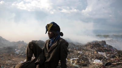 Guerdy Joseph, a 24-year-old trash scavenger, rests in his protective clothing, including a Christmas costume hat that he found in the trash, at the end of his work day at the Truitier landfill. AP Photo
