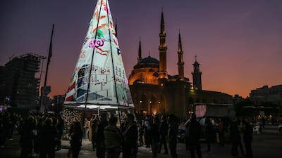 Anti-government demonstrators gather at an illuminated Christmas tree made from protest banners at Martyrs Square in Beirut. EPA