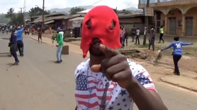 A still image taken from a video shot on October 1, 2017, shows an unidentified masked independence protester gesturing along a street in the English-speaking city of Bamenda, Cameroon. Reuters