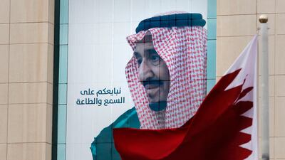 A Qatari flag flies in front of a portrait of Saudi King Salman in Riyadh ahead of the 40th GCC summit on December 10, 2019. AP Photo