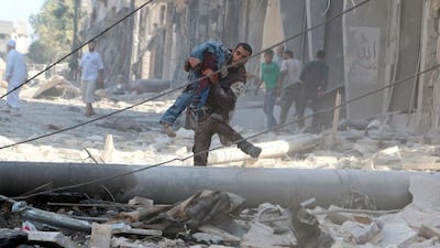 A man carries an injured man amid the rubble of damaged buildings after an air strike on Aleppo's rebel-held Al Fardous district on July 16, 2016. Abdalrhman Ismail/Reuters