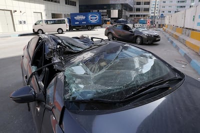 A falling crane crushed a number of vehicles when it collapsed in the Tourist Club area. Pawan Singh / The National