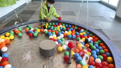A child takes part in a water activity at the OliOli summer camp. Chris Whiteoak / The National