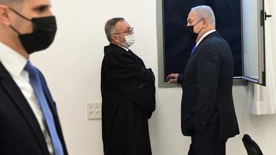 Israeli Prime Minister Benjamin Netanyahu wearing a protective face mask, speaks to a member from his legal team before the start of a hearing in his corruption trial at Jerusalem's District Court. Reuters