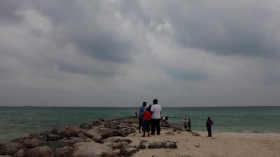 People enjoy the cool and wet weather on Sharjah beach. Jeffrey E Biteng / The National