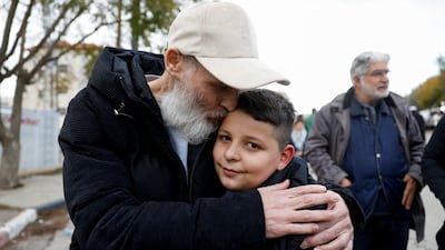 A freed Palestinian detainee hugs a boy after arriving in Ramallah, in the occupied West Bank. Reuters