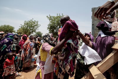 Red Cross workers help a Sudanese child who fled the conflict in Geneina in Sudan's Darfur region. Reuters