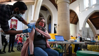 A member of the public receives a Covid-19 Moderna booster vaccine jab at a temporary vaccination centre set up inside St John's Church in west London. AFP