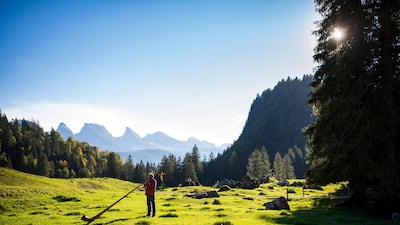 Stephan Ruegg, a tourist from Winterthur, plays his alphorn in the outdoors on Alp Laui in Unterwasser, Switzerland. EPA