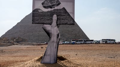 An installation titled 'Greetings From Giza' by French artist and photographer Jean Rene, better known as JR, at the ancient Giza Necropolis on October 23, 2021. AFP; Art D'Egypte