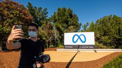 A person takes a selfie in front of a newly unveiled logo for 'Meta' outside Facebook headquarters in Menlo Park, California. AFP