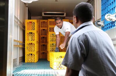 Workers unload a food collection truck at the UAE Food Bank in Al Quoz. Pawan Singh / The National