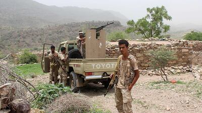 A Yemeni pro-government fighter poses in front of an armed pick-up.