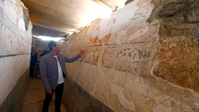 A guide from the Egypt's Ministry of Antiquities examines wall paintings in a recently discovered tomb at the Giza plateau after it was opened for viewing on February 3, 2018. Amr Abdallah Dalsh / Reuters