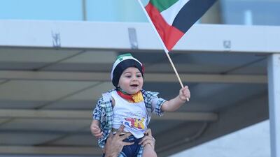 The young UAE fan is hoisted in the air to wave a flag and watch his team secure their place in the quarter-finals.