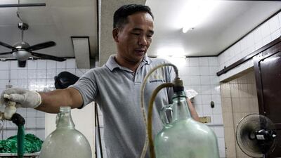 Funeral home worker Alejandro Ormeneta prepares embalming instruments before operating on a body inside the morgue of the Veronica Memorial Chapel in Manila on October 30, 2016. Noel Celis/AFP