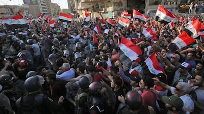 Iraqi protesters shout slogans and wave national flags in the capital Baghdad's Tahrir Square. AFP