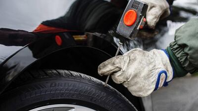 Hammering a nail into one of Bridgestone’s DriveGuard ‘run-flat’ tyres. Courtesy Aston Martin Lagonda