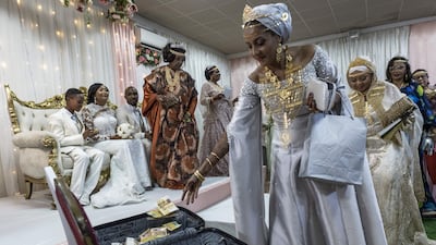 People drop banknotes in a suitcase while dancing during Ukumbi, a women-only reception marking the end of Grand Mariage celebrations, in Moroni, Comoros. AFP
