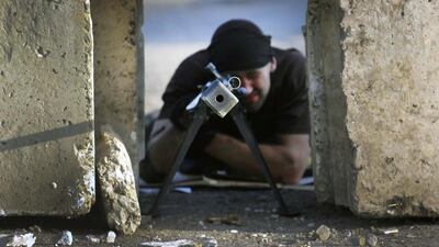 A pro-Russian rebel aims his anti-tank rifle between blocks of concrete at a front line rebel position near the eastern Ukrainian village of Semenivka. Yannis Behrakis / Reuters