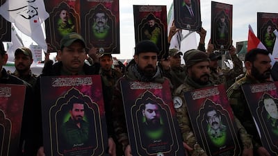 Members of Iraq's Hashed Al Shaabi group carry portraits of people killed by US strikes. AFP