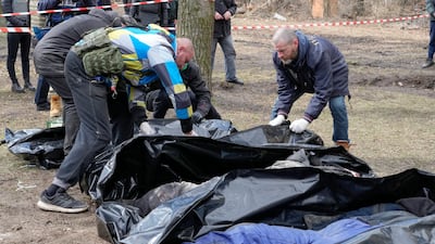 Volunteers collect bodies of murdered civilians in Bucha on Monday. AP