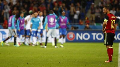 Belgium’s Eden Hazard looks dejected as Italy celebrate their second goal in their Euro 2016 match in Lyon. Kai Pfaffenbach / Reuters