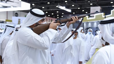 Sheikh Rashid inspects a rifle at Adihex 2021. Wam