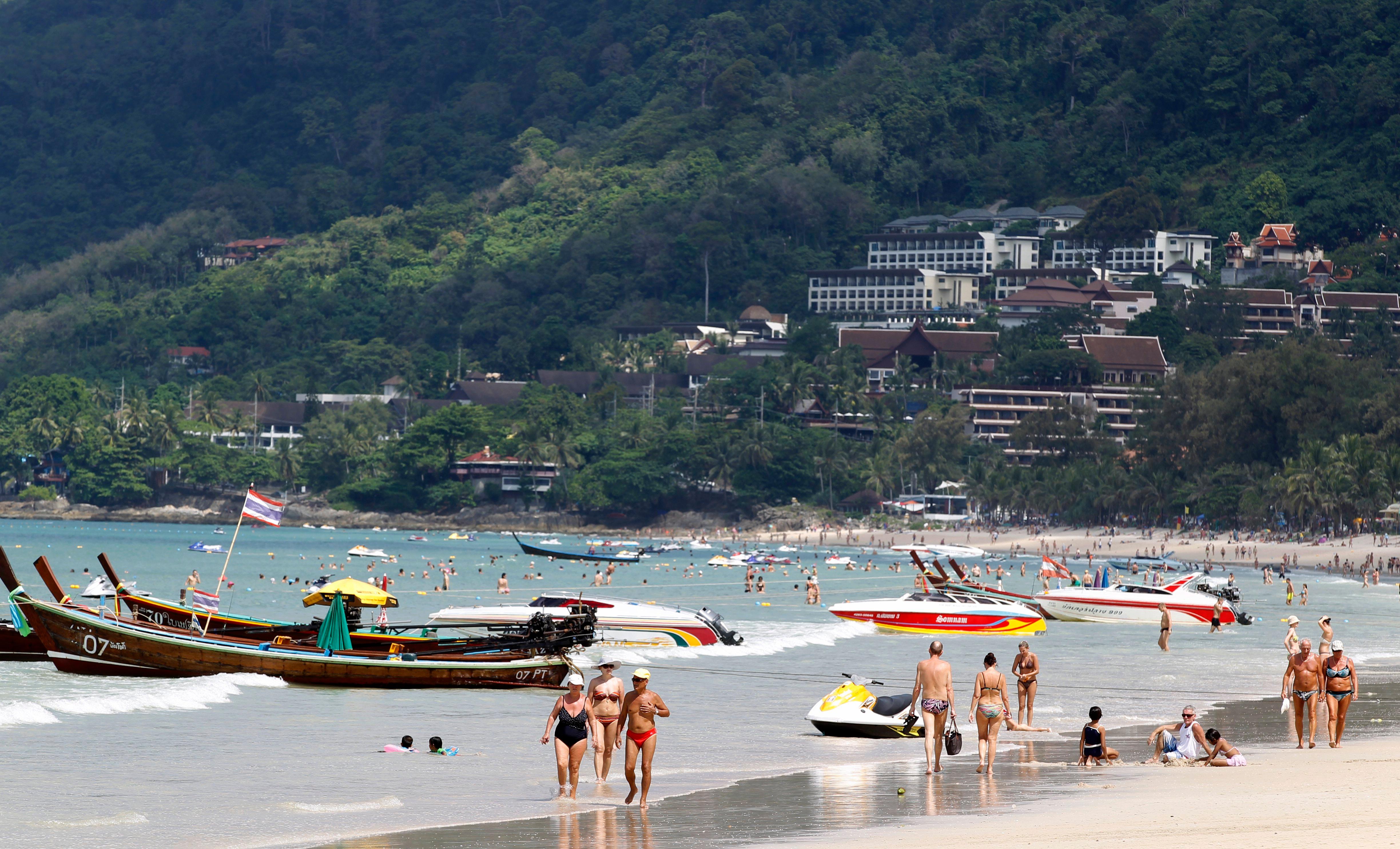 Tourists walk along Patong beach on the island of Phuket in southern Thailand on November 30, 2014. Yongyot Pruksarak / EPA