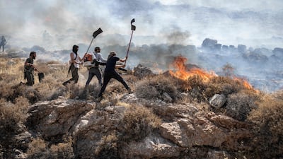 Israeli settlers tackle a wildfire near the Ein Samiya spring in the occupied West Bank. AFP