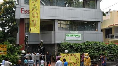 Crowds watch as Greenpeace activists climb down their office building to unfurl banners, reading 'democracy' and 'free speech' in Bangalore on May 15, 2015. Manjunath Kiran/AFP Photo