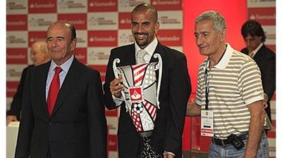 Estudiantes' Juan Sebastian Veron, centre, receives the Copa Libertadores best player trophy on Thursday from the Santander group president Emilo Botin. On the right is Veron's father and former Estudiantes player, Juan Ramon Veron.