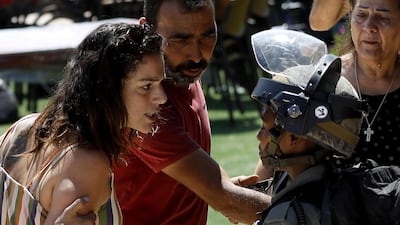 A Palestinian women confronts an Israeli soldier. Palestinian officials said Israel demolished the building because the owner didn't have permits.