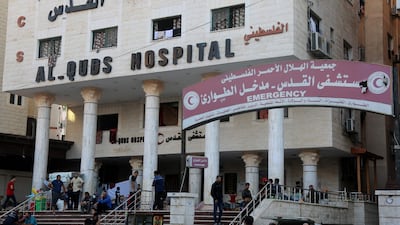 People wait outside Gaza City's Al Quds Hospital on October 29, 2023. AFP