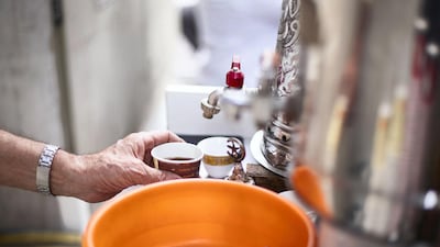 Mr Al Khawaldi pours a cup of coffee for a customer.
