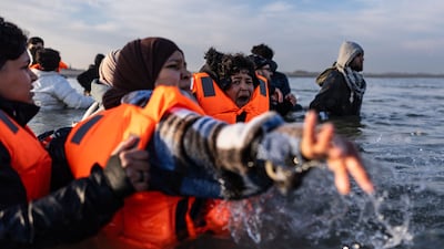 Migrants try to board a smugglers' boat off France's northern coast, as they attempt to cross the Channel to the UK. AFP
