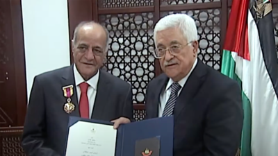 Palestinian President Mahmoud Abbas decorates novelist Gharib Asqalani with the Order of Culture, Sciences and Arts.