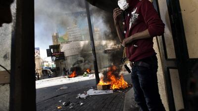Masked man: a Palestinian demonstrator protects himself from tear gas in the streets of the West Bank city of Hebron during clashes with the Israeli army following the death of a Palestinian prisoner. Marco Longari / AFP