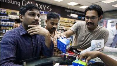 December 14, 2010 - Abu Dhabi, UAE - Men look at different mobile phone brands to decide what to buy at Golden Crown Mobiles on Defence Rd. in Abu Dhabi on Tuesday December 14, 2010. (Andrew Henderson/The National)