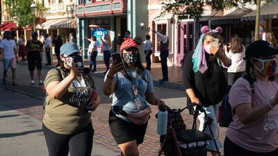Guests wearing protective masks walk along Main Street USA during the reopening of the Disneyland theme park in Anaheim, California, US, on Friday, April 30, 2021. Bloomberg