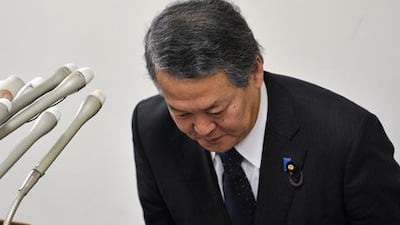 Japanese Justice Minister Minoru Yanagida bows deeply as he announces his resignation.