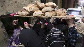 Women buy subsidised bread through the window of a bakery in Cairo. Reuters