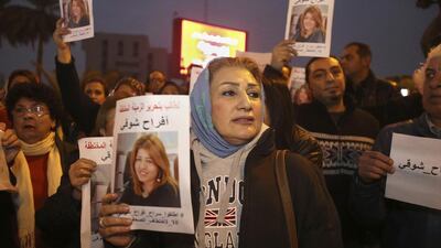 Protesters demand the release of kidnapped journalist Afrah Shawqi Al Qaisi, seen pictured in posters, in Baghdad. The journalist was released on January 3. Karim Kadim / AP Photo