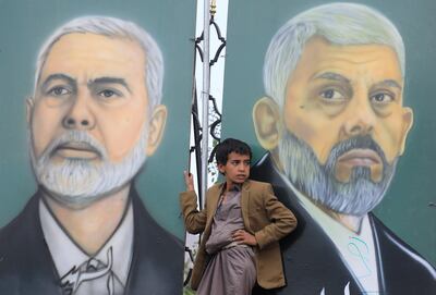 A boy stands in front of murals depicting late Hamas leaders Yahya Sinwar, right, and Ismail Haniyeh in Sanaa, Yemen. EPA