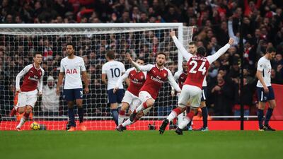 Shkodran Mustafi, centre, celebrates after scoring the opening goal in Arsenal's victory over Tottenham Hotspur on Saturday. Mike Hewitt / Getty Images