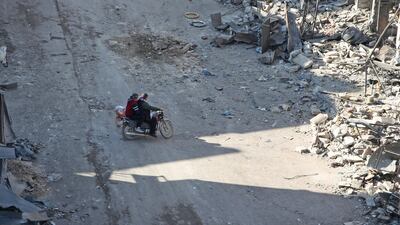 Syrian men ride a motorcycle through a damaged neighbourhood in Maaret Al-Numan city in Syria's northwestern Idlib province. AFP